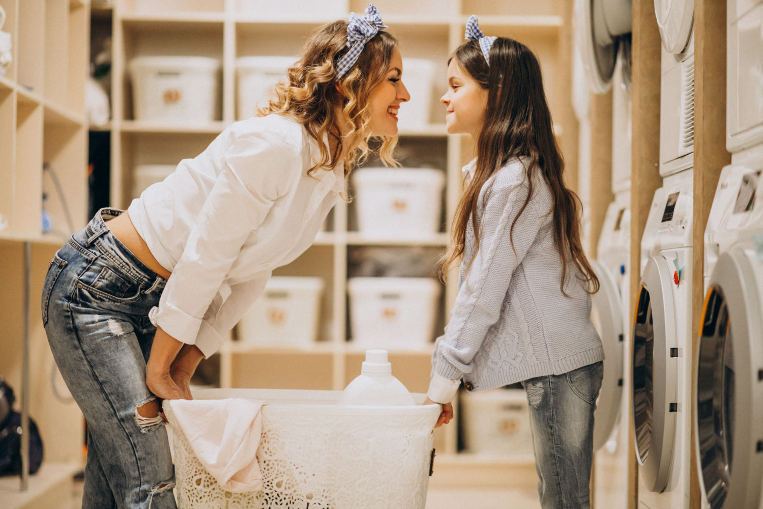 Mujer y niña frente a frente sonriendo y tocando sus narices en un ambiente interior